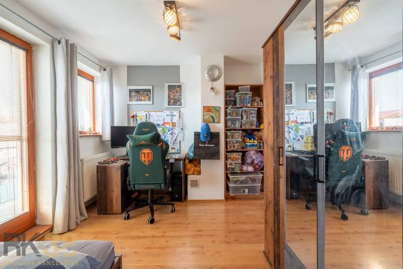 Predaj priestranného rodinného domu v historickej časti Popradu  - Domáca kancelária s herným kreslom, stolným počítačom a skriňou, podlaha s dreveným dekorom.