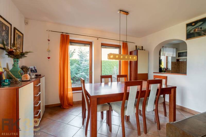 Predaj priestranného rodinného domu v historickej časti Popradu  - Jedenásťdielna jedálenská súprava v rodinnom dome s oranžovými závesmi a dlažbou.