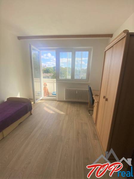 PRENÁJOM - 4 - izbový byt Košice - Západ, Obchodná ulica  - Svetlá izba v 4-izbovom byte s balkónom a podlahou s dreveným dekorom.