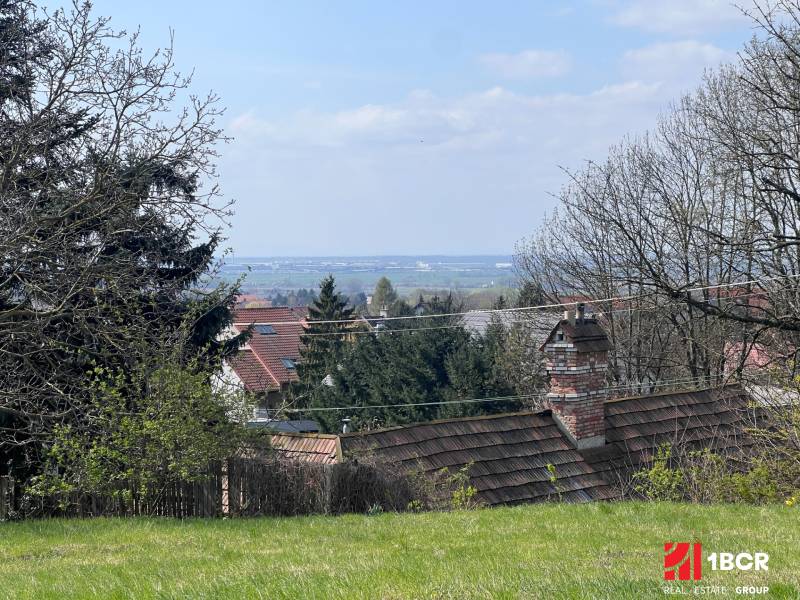 STAVEBNÝ POZEMOK S DUŠOU LEN PÁR MINÚT OD BRATISLAVY V OBCI MARIANKA - Záhrady s výhľadom medzi stromami a strechami na Budovateľskej ulici, Marianka, Pozemky - bývanie.