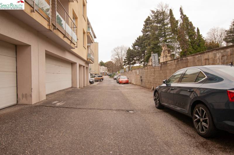 Predáme krásny Veľký 2 izb byt na Kolibe  - Ulica Na pažiti, Bratislava - Nové Mesto, zobrazuje parkovisko a obytné budovy s garážami.