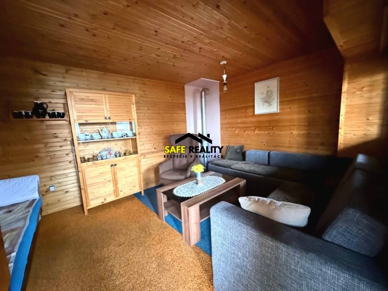 Záhradná chatka, Žilina - Dubeň - Interiér chaty s dreveným dekorom, pohodlnými sedačkami a vitrínou na riad.