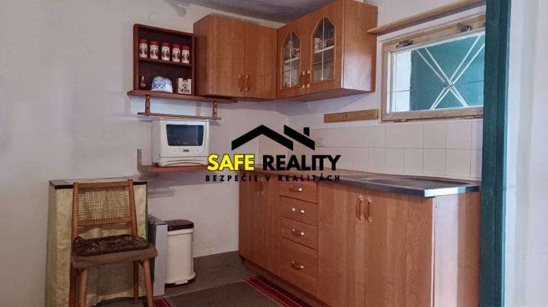 Záhradná chatka, Žilina - Dubeň - Kuchynka na chate s dreveným nábytkom a mikrovlnkou, podlaha s dreveným dekorom.