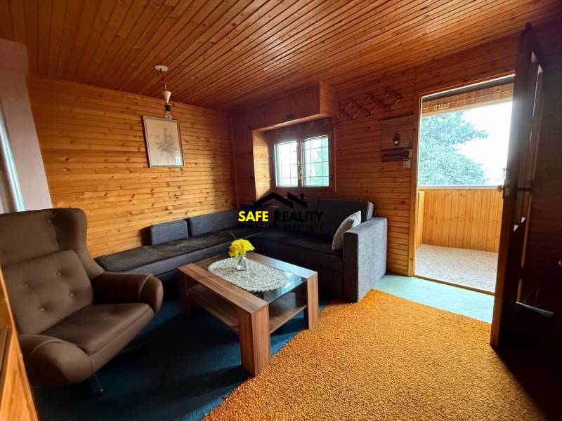 Záhradná chatka, Žilina - Dubeň - Interiér chaty s posedením a dreveným obložením.