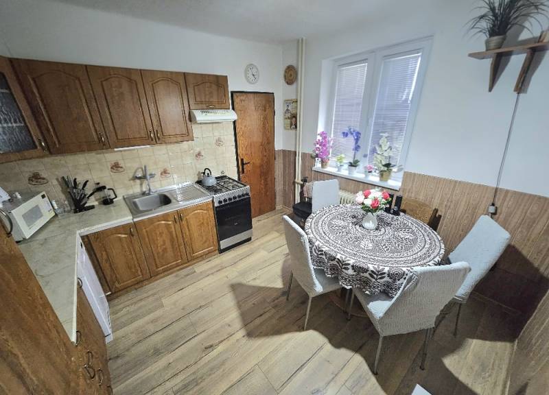 RODINNÝ DOM - HORNÉ OZOROVCE-POZEMOK 566 m2- 3,5 IZBOVÝ/ GARÁŽ - Kuchyňa v rodinnom dome s dreveným dekorom, s jedálenským stolom a kuchynskou linkou.