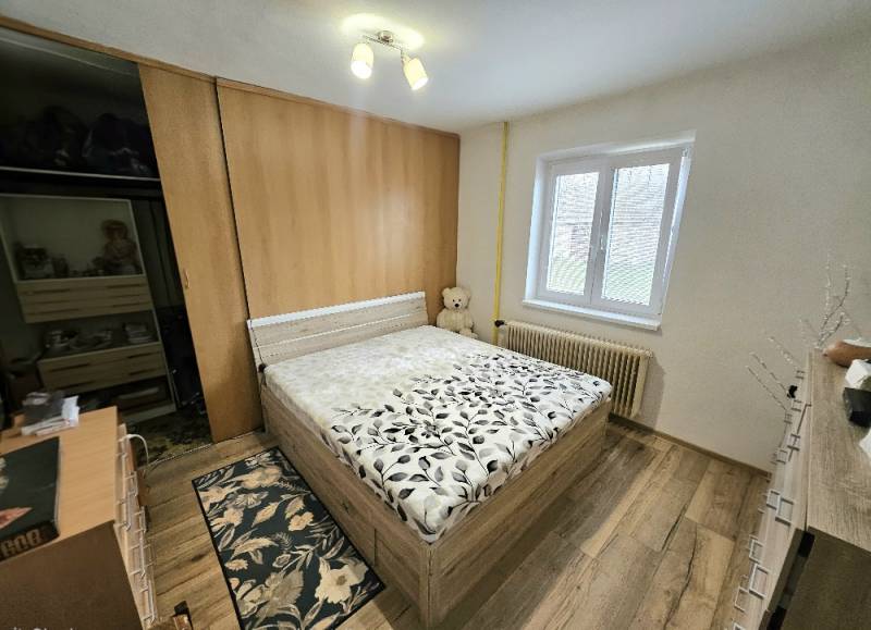 RODINNÝ DOM - HORNÉ OZOROVCE-POZEMOK 566 m2- 3,5 IZBOVÝ/ GARÁŽ - Spálňa s postelí a podlahou s dreveným dekorom v rodinnom dome.