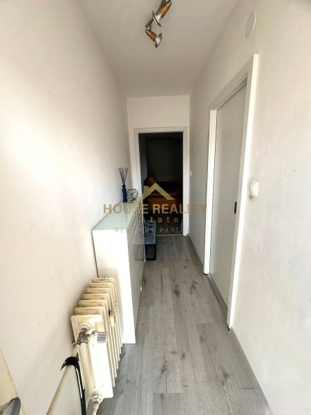 Prenájom pekný 2 izbový byt Šancová ulica, Bratislava III. Nové Mesto - Úzka chodba s podlahou s dreveným dekorom a radiátorom v 2-izbovom byte.