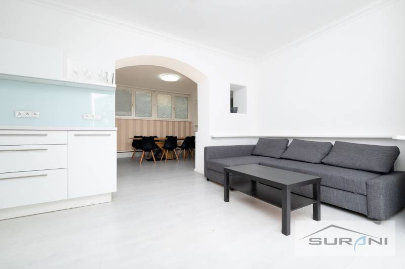 PRENÁJOM 4-IZBOVÉHO BYTU | ZÁHRADA | DVOJGARÁŽ | KRČMÉRYHO ULICA - Obývacia izba 4-izbového bytu s kuchynským kútom a sedacou súpravou.