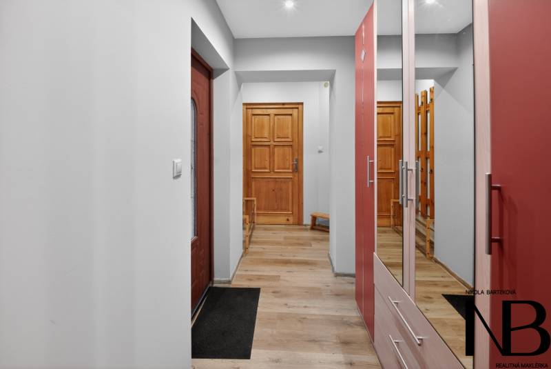 Rodinný dom s veľkým pozemkom a priestorom na podnikanie – T.Jastrabie - Chodba s drevenými dverami a podlahou s dreveným dekorom v rodinnom dome.