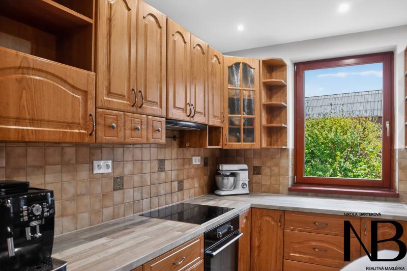 Rodinný dom s veľkým pozemkom a priestorom na podnikanie – T.Jastrabie - Kuchyňa v rodinnom dome s dreveným dekorom a výhľadom cez okno na zeleň.