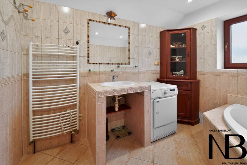Rodinný dom s veľkým pozemkom a priestorom na podnikanie – T.Jastrabie - Kúpeľňa v rodinnom dome s práčkou, umývadlom, zrkadlom a dreveným nábytkom.