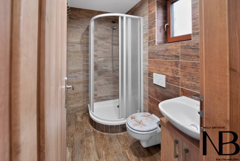 Rodinný dom s veľkým pozemkom a priestorom na podnikanie – T.Jastrabie - Kúpeľňa v rodinnom dome s podlahou a stenou s dreveným dekorom.