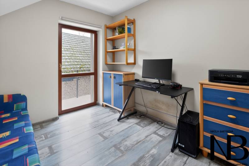 Rodinný dom s veľkým pozemkom a priestorom na podnikanie – T.Jastrabie - Pracovňa s modrým nábytkom, počítačom a podlahou s dreveným dekorom v rodinnom dome.