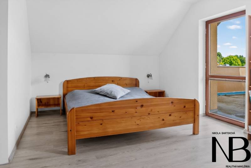 Rodinný dom s veľkým pozemkom a priestorom na podnikanie – T.Jastrabie - Spálňa v rodinnom dome s drevenou posteľou, podlaha s dreveným dekorom.