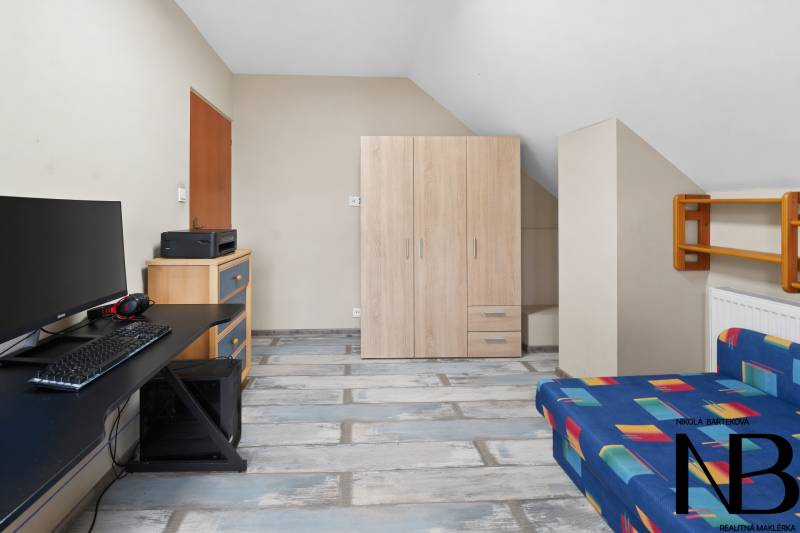 Rodinný dom s veľkým pozemkom a priestorom na podnikanie – T.Jastrabie - Pracovňa s počítačovým stolom, pohovkou a podlahou s dreveným dekorom v rodinnom dome.