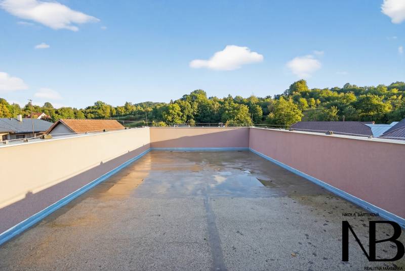 Rodinný dom s veľkým pozemkom a priestorom na podnikanie – T.Jastrabie - Terasa rodinného domu v Trenčianskom Jastrabí s výhľadom na zeleň a strechy.