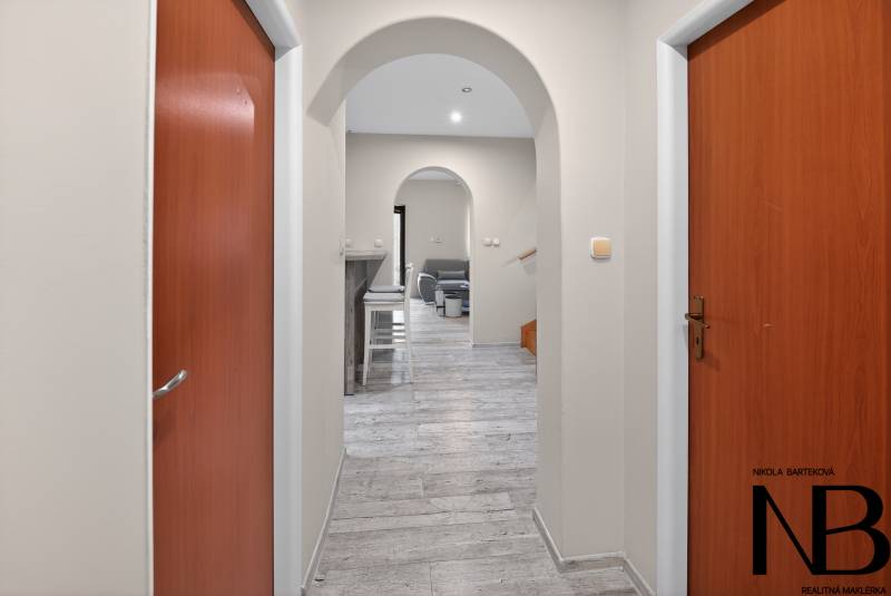 Rodinný dom s veľkým pozemkom a priestorom na podnikanie – T.Jastrabie - Chodba v rodinnom dome s oblúkovými dverami a podlahou s dreveným dekorom.