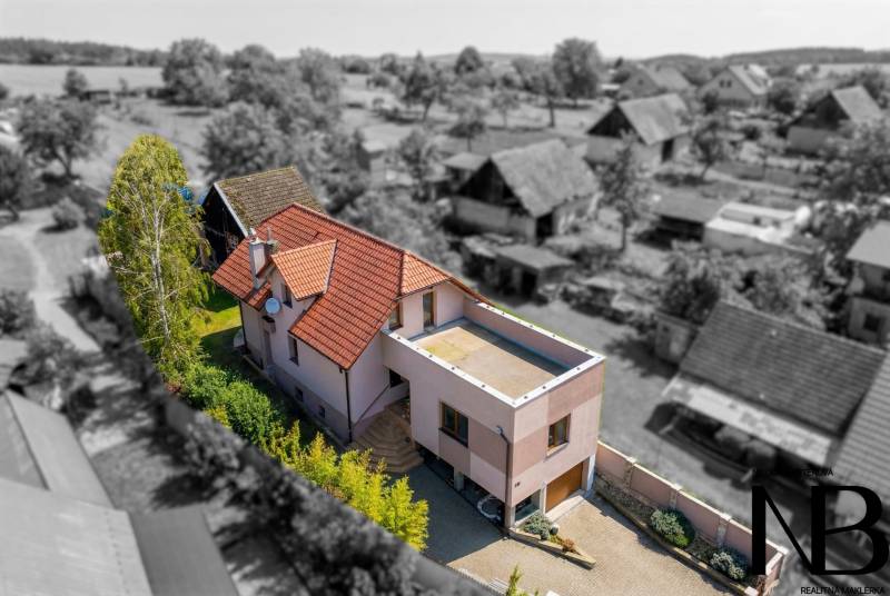 Rodinný dom s veľkým pozemkom a priestorom na podnikanie – T.Jastrabie - Rodinný dom v Trenčianskom Jastrabí, s červenou strechou a zelenou záhradou.