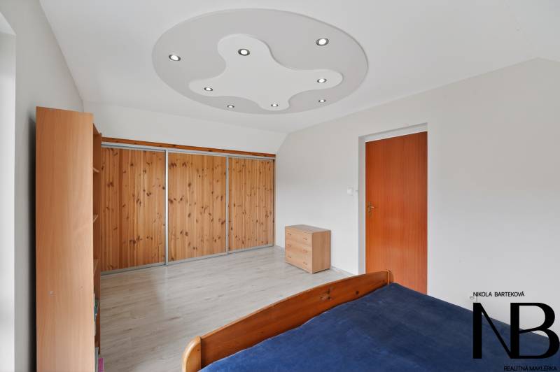 Rodinný dom s veľkým pozemkom a priestorom na podnikanie – T.Jastrabie - Izba v rodinnom dome s podlahou s dreveným dekorom a vstavanými skriňami.