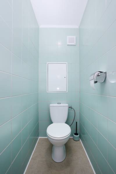NA PREDAJ-3-izbový byt s loggiou a výhľadom na centrum mesta, KE-JUH - Toaleta v 3-izbovom byte s bledomodrými kachličkami a podlahou svetlej farby.