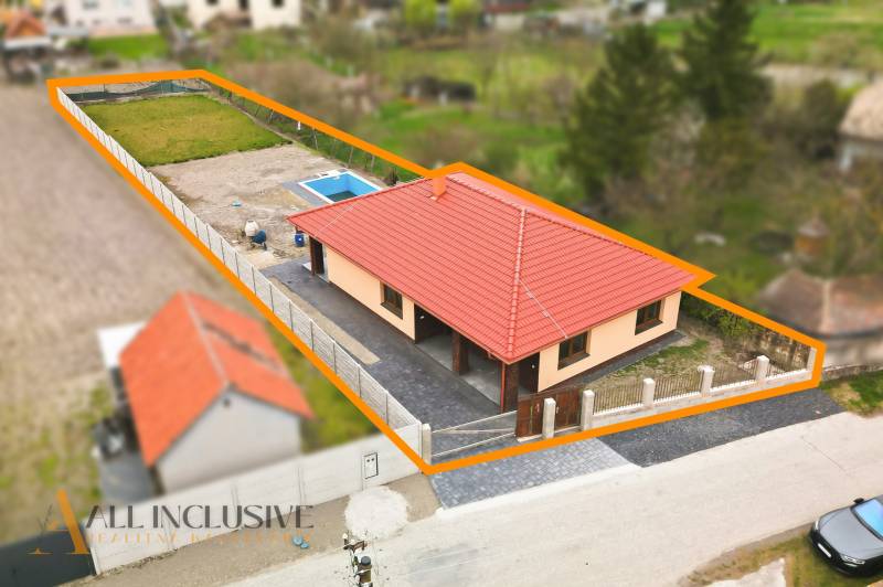 Na predaj 4-izb. novostavba s bazénom, Horné Mýto - Rodinný dom v Hornom Mýte s červenou strechou a bazénom na dvore.