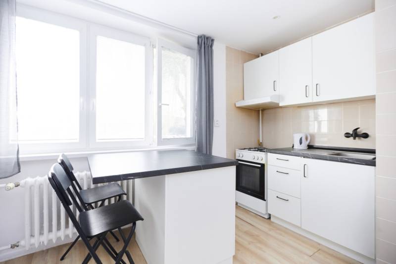 NA PREDAJ,2-IZBOVÝ TEHLOVÝ BYT,KOŠICE-SEVER,LOMNICKÁ UL. - Kuchyňa v 2-izbovom byte s pultom a podlahou s dreveným dekorom.