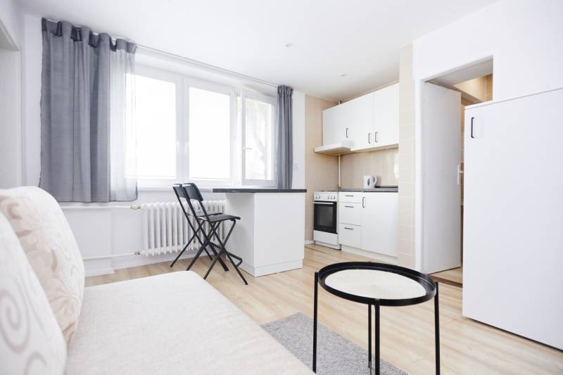 NA PREDAJ,2-IZBOVÝ TEHLOVÝ BYT,KOŠICE-SEVER,LOMNICKÁ UL. - Kuchyňa v 2-izbovom byte s bielym nábytkom a podlahou s dreveným dekorom.