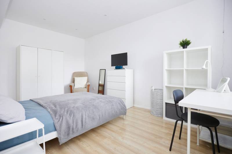 NA PREDAJ,2-IZBOVÝ TEHLOVÝ BYT,KOŠICE-SEVER,LOMNICKÁ UL. - Spálňa v 2-izbovom byte s bielym nábytkom a podlahou s dreveným dekorom.