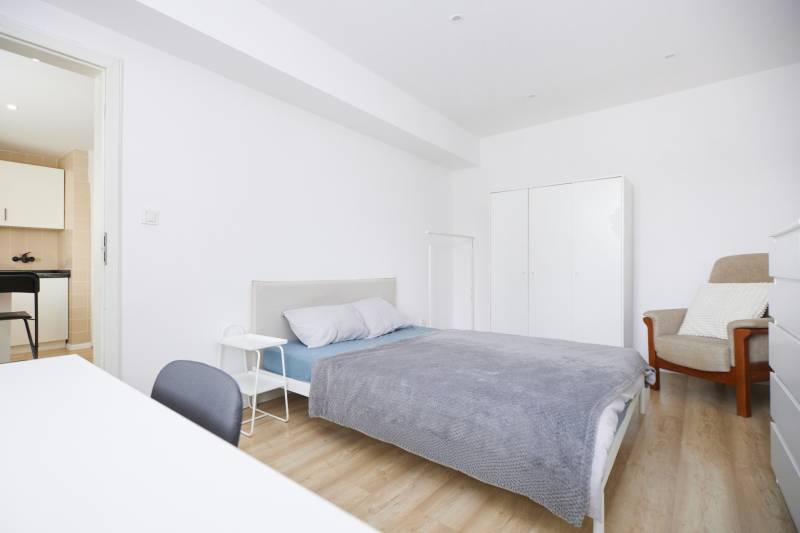 NA PREDAJ,2-IZBOVÝ TEHLOVÝ BYT,KOŠICE-SEVER,LOMNICKÁ UL. - Spálňa 2-izbového bytu s posteľou, skriňou a podlahou s dreveným dekorom.