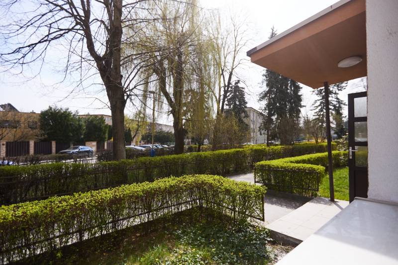 NA PREDAJ,2-IZBOVÝ TEHLOVÝ BYT,KOŠICE-SEVER,LOMNICKÁ UL. - Záhrada s chodníkom a zaparkované autá na Lomnickej ulici v Košiciach, mestská časť Sever.