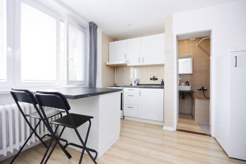 NA PREDAJ,2-IZBOVÝ TEHLOVÝ BYT,KOŠICE-SEVER,LOMNICKÁ UL. - Kuchyňa v 2-izbovom byte s barovým pultom a podlahou s dreveným dekorom.