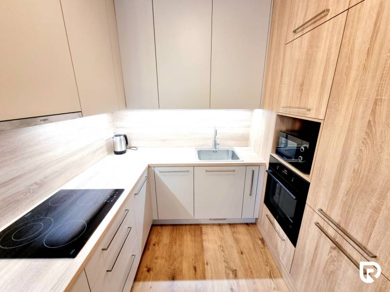 REZERVOVANÉ I Posledný investičný krásny 2-izbový byt | 62 m² | - Kuchyňa s podlahou s dreveným dekorom v 2-izbovom byte, so zabudovanými spotrebičmi.