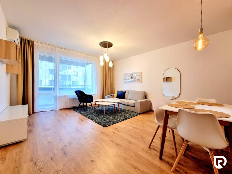REZERVOVANÉ I Posledný investičný krásny 2-izbový byt | 62 m² | - Obývacia izba v 2-izbovom byte so sedačkou, jedálenským stolom a podlahou s dreveným dekorom.