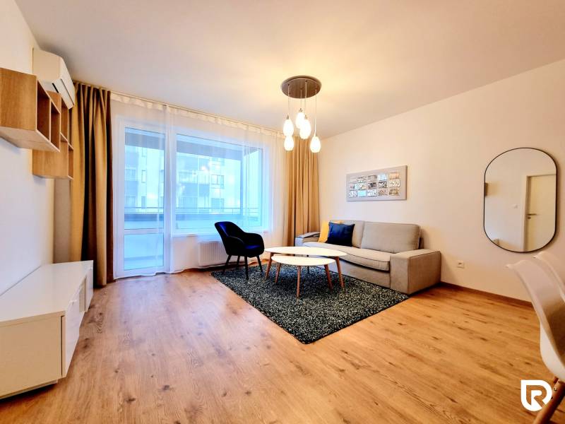REZERVOVANÉ I Posledný investičný krásny 2-izbový byt | 62 m² | - Obývacia izba s pohovkou a podlahou s dreveným dekorom v 2-izbovom byte.