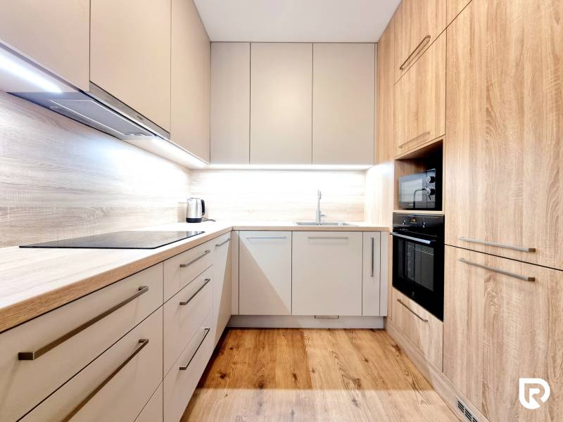 REZERVOVANÉ I Posledný investičný krásny 2-izbový byt | 62 m² | - Svetlá kuchyňa s podlahou s dreveným dekorom a vstavanými spotrebičmi v 2-izbovom byte.