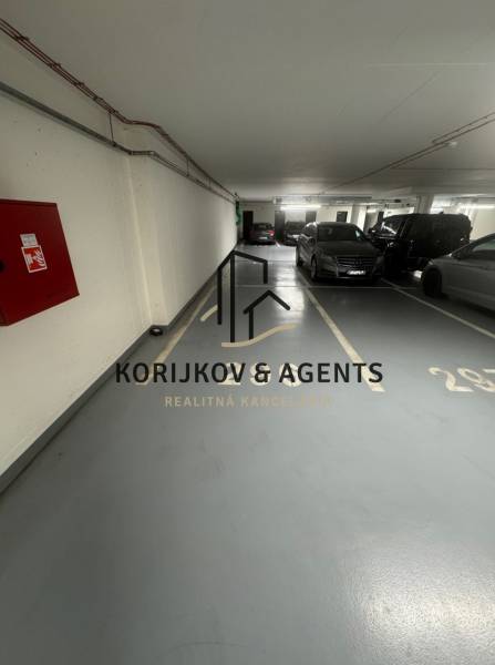 PREDAJ, parkovacie miesto v podzemnej garáži v rezidenci ALBELLI - Parkovacie miesta v Garáži s autami a miestami na státie, logom Korijkov & Agents.