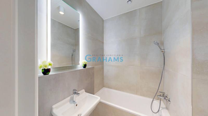 Nový, ešte neobývaný 1,5-izbový byt, parkovanie, Metropolis, Bottova - Kúpeľňa v 2-izbovom byte, s vaňou a umývadlom, veľké zrkadlo nad umývadlom.