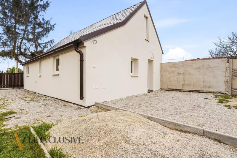 Na predaj 2,5-izbový rodinný dom, Dolný Bar - Rodinný dom v Dolnom Bare s bielou fasádou a šikmou strechou na štrkovom pozemku.