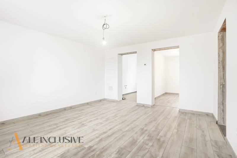 Na predaj 2,5-izbový rodinný dom, Dolný Bar - Biela miestnosť v Rodinnom dome s podlahou s dreveným dekorom a holou žiarovkou.