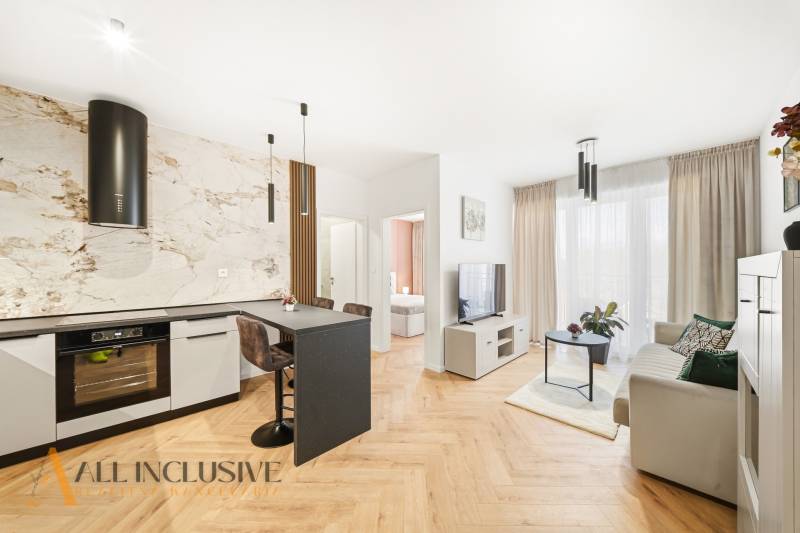 Na prenájom 2-izb. byt s terasou, Dun. Streda -Florida - Obývacia izba a kuchyňa v 4-izbovom byte s podlahou s dreveným dekorom a svetlou výzdobou.