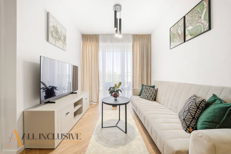 Na prenájom 2-izb. byt s terasou, Dun. Streda -Florida - Obývacia izba v 4-izbovom byte s podlahou s dreveným dekorom, svetlým nábytkom a pohovkou.