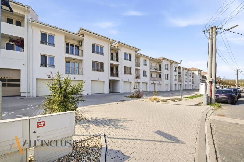 Na prenájom 2-izb. byt s terasou, Dun. Streda -Florida - Súbor bielych budov a parkovacích miest v Dunajskej Strede, ideálny pre 4-izbový byt.