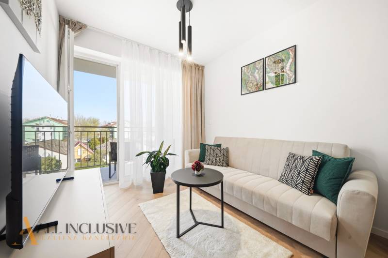 Na prenájom 2-izb. byt s terasou, Dun. Streda -Florida - Obývacia izba v 4-izbovom byte s balkónom, pohovkou a podlahou s dreveným dekorom.