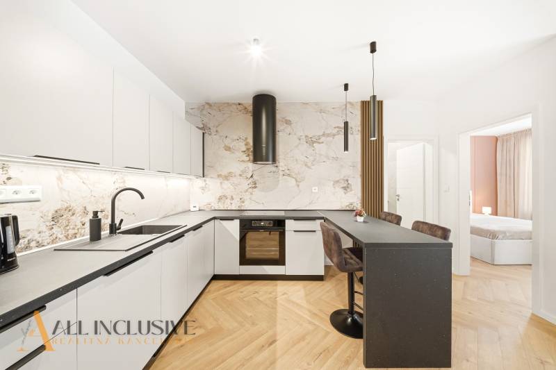 Na prenájom 2-izb. byt s terasou, Dun. Streda -Florida - Kuchyňa s pultom a podlahou s dreveným dekorom v 4-izbovom byte.