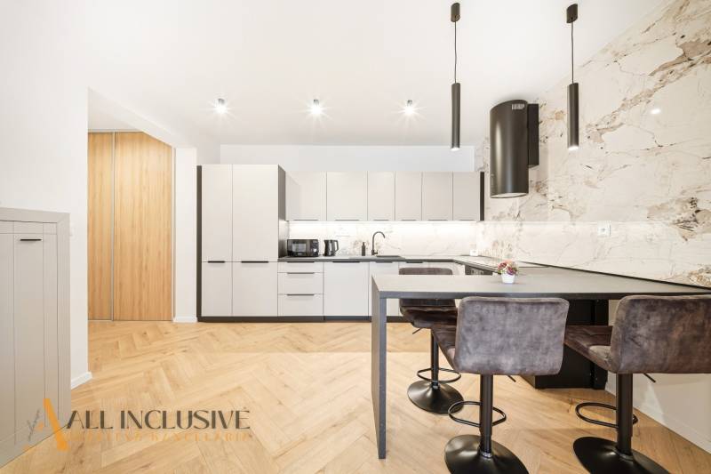 Na prenájom 2-izb. byt s terasou, Dun. Streda -Florida - Kuchyňa v 4-izbovom byte s podlahou s dreveným dekorom a štýlovými svietidlami.