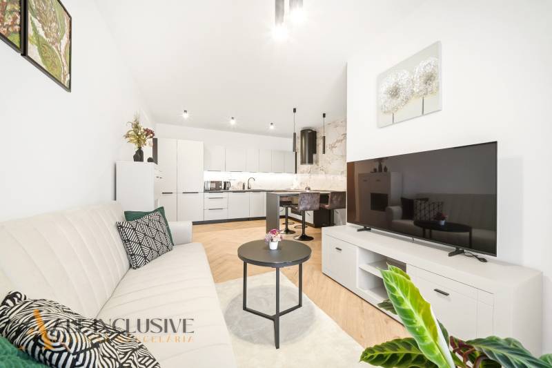 Na prenájom 2-izb. byt s terasou, Dun. Streda -Florida - Obývacia izba s kuchyňou v 4-izbovom byte s podlahou s dreveným dekorom.