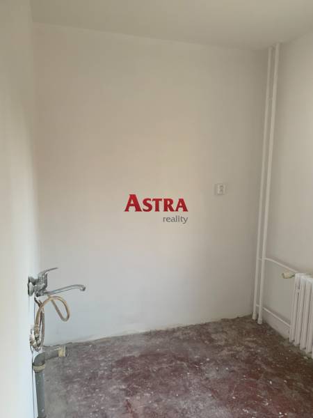 2 IZBOVÝ BYT, KOŠICE – ŠIRŠIE CENTRUM - Prázdna miestnosť v 2-izbovom byte bez podlahovej krytiny a s umývadlom.