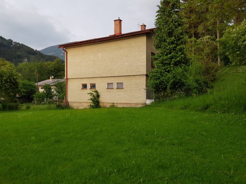 PREDAJ – Rodinný dom s druhou samostatnou stavbou, garážou  - Rodinný dom v Blatnici na ulici Blatnica obklopený zeleňou a stromami, v pozadí hory.