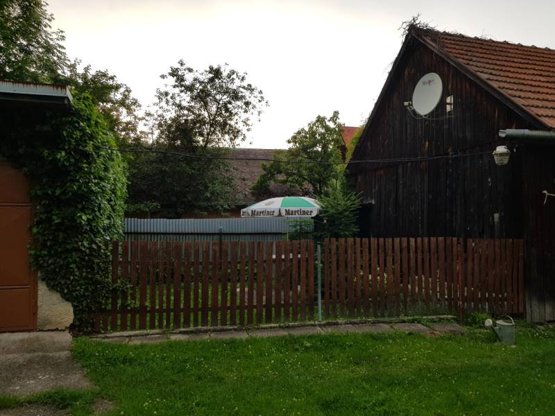 PREDAJ – Rodinný dom s druhou samostatnou stavbou, garážou  - Drevený rodinný dom v Blatnici s dreveným plotom a satelitnou anténou.