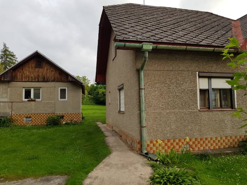 PREDAJ – Rodinný dom s druhou samostatnou stavbou, garážou  - Rodinný dom v Blatnici na ulici Blatnica s dvomi stavbami a zeleným trávnikom.